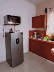 a kitchen with a microwave on top of a refrigerator at Estrella de Mar: Departamento en Progreso in Progreso