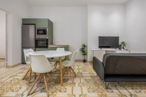 uma sala de estar com uma mesa e cadeiras e um sofá em New & luxury apartment - 5 min walk to the Capital em Floriana