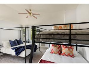 two bunk beds in a room with a ceiling fan at Round Rocker l Backyard & BBQ l Sleeps 14 l in Round Rock