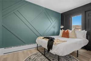 a bedroom with a large bed with a blue wall at The Marble in Drumheller