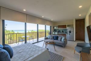 Habitación con cama y sala de estar con balcón. en Ocean View Loft in Punta Cocos - C102 en Holbox Island