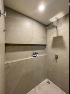 a bathroom with a shower with three bottles on a shelf at Ocean View Loft! - Punta Cocos in Holbox Island