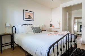 een slaapkamer met een groot bed met witte lakens bij Rancho Del Sol l Sleeps 5 l Close to Downtown I TV in Austin