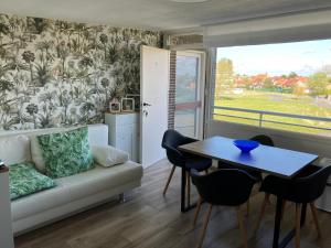 a living room with a couch and a table at Lovely Acacia in De Haan