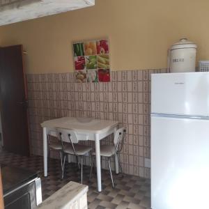 Il comprend une cuisine équipée d'une table blanche et d'un réfrigérateur. dans l'établissement Casa Furtado, à Burgau