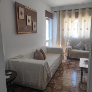 - un salon avec un canapé blanc et une table dans l'établissement Casa Furtado, à Burgau