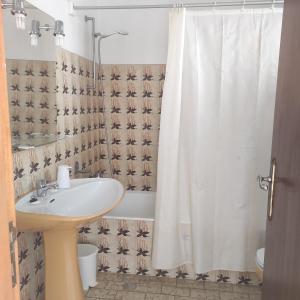 a bathroom with a sink and a shower curtain at Casa Furtado in Burgau