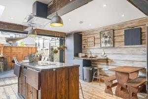 an open kitchen with wooden walls and a wooden counter top at Stylish House w Free Parking Nr Exeter Centre in Exeter