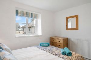 um quarto com uma cama, uma cómoda e uma janela em Cosy Cottage Huge Garden w Lake BBQs & Seating em Slapton