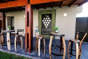 a patio with two tables and chairs and a sign at Wineland Logde East 2Pax. - by Inside in Ciudad Lujan de Cuyo +5 photos