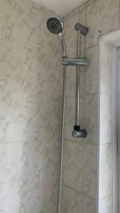 y baño con ducha con cabezal de ducha. en Luxury Top Quality natural Bedroom Near the Train Station, en Barking
