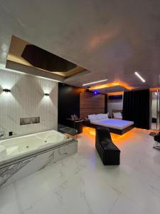 Prestige Motel 3 في سوروكابا: حمام كبير مع حوض استحمام وسرير