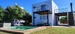 una villa con un'amaca e una casa di GreyStone a Balneario Buenos Aires