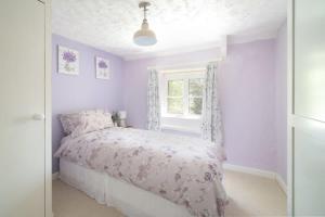 a bedroom with a bed and a window at Idyllic Cottage in Dorset Garden & Parking in Gillingham