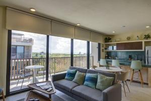 salon z kanapą i balkonem w obiekcie Beautiful Ocean View Penthouse With Private Pool -C301 w mieście Isla Holbox