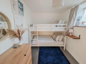 1 dormitorio con 2 literas y alfombra azul en Charming Cottage with Stunning Views, en Calstock