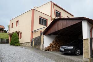a car parked next to a building with a pile of logs at Apartmán U Onky in Luhačovice