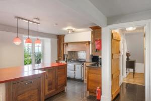 a kitchen with wooden cabinets and a red counter top at Secluded Cottage w Expansive Sea Views & Garden in Culbone