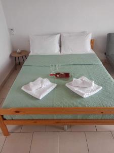 Una cama con dos vasos y toallas. en Matenia’s house, en Mángana