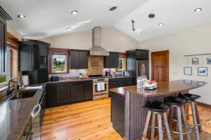 a kitchen with black cabinets and a island with bar stools at Sleep 14! Hot tub, Indoor Pickleball & Basketball Court in Belgrade