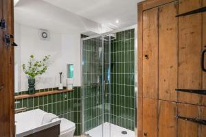 a bathroom with a shower with green tiles at Secluded Cottage w Expansive Sea Views & Garden in Culbone