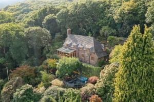 an aerial view of a house in the middle of a forest at Secluded Cottage w Expansive Sea Views & Garden in Culbone