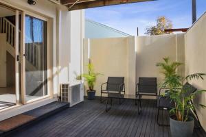 a patio with two chairs and a table on a balcony at Little Malop Escape I Central Geelong in Geelong