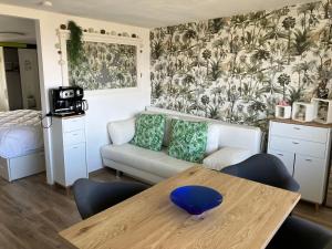 a living room with a couch and a table at Lovely Acacia in De Haan +14 photos