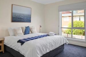 a bedroom with a large bed and a large window at Little Malop Escape I Central Geelong in Geelong