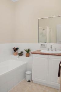 a white bathroom with a sink and a mirror at Little Malop Escape I Central Geelong in Geelong