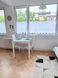 a white table and chairs in a room with a window at Angela's house in Sofia