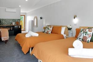 um quarto com 2 camas com lençóis laranja em 14 Scenic Studio em Geelong