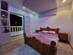 a bedroom with a wooden bed and a window at Résidence Karim in Djerba