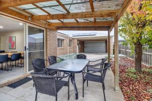 a patio with a table and chairs under a pergola at Reconnect on Daly I Epworth and Deakin in Geelong