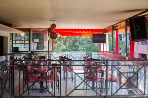 a restaurant with a bar with red chairs and a television at Capital Heights Hotel in Nairobi