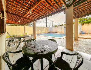 un patio con tavolo e sedie e una piscina di Casa com piscina a 350m da Praia do Croa Alagoas a Barra de Santo Antônio