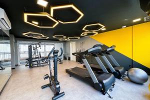 a gym with cardio equipment in a room with yellow walls at APTO 902 luxuoso | Piscina, A/C e Wi-fi 500 mb in Sao Paulo