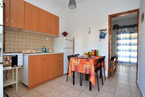 a kitchen with a table and a refrigerator at Maria Konstantinidis Apartments in Nea Potidaea