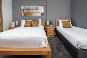 a bedroom with two beds and a mirror at Boars Head Hotel in Carmarthen