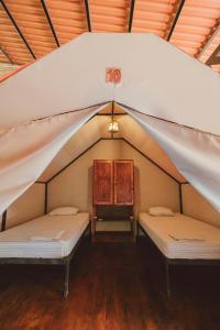 a room with two beds in a tent at Habitat Surf Glamp in Santa Teresa Beach