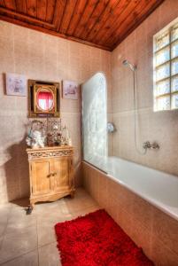 a bathroom with a tub and a red rug at The Estate of Thebes in Loukísia