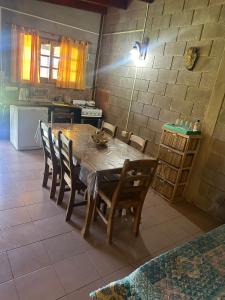 cocina con mesa de madera y sillas en una habitación en Cabañas Los Frutales en Santa María