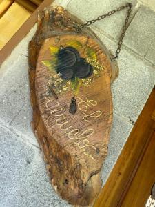 un cartel de madera con un pájaro pintado en él en Cabañas Los Frutales en Santa María