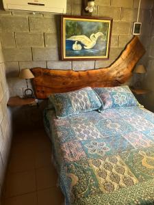 1 dormitorio con 1 cama con cabecero de madera en Cabañas Los Frutales en Santa María
