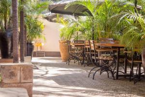 a patio with tables and chairs and palm trees at Capital Heights Hotel in Nairobi