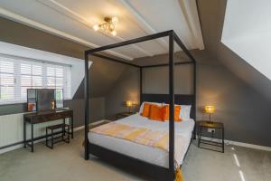 een slaapkamer met een hemelbed en een bureau bij Spacious 4Bed Home: Elegant Garden & Parking in Windsor