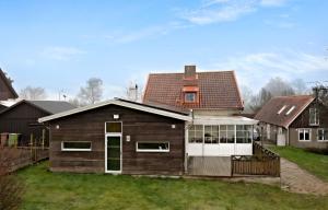 een bruin huis met een witte deur in een tuin bij hus,2 sovrum, 2 våning, 2 badrum in Simrishamn