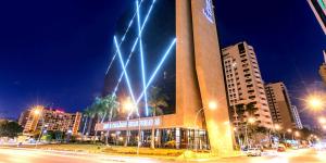un edificio con luces encendidas en una ciudad por la noche en Cullinan Hplus Premium Flat Vip en Brasilia