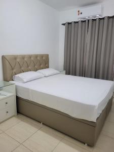 1 dormitorio con cama grande y cortina en Egidios AP en São Pedro da Aldeia