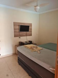 um quarto com uma cama e uma televisão de ecrã plano em Rancho da Malu em Taubaté